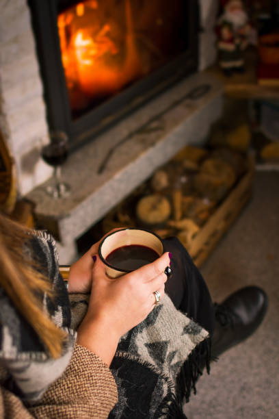 istock Woman drinking mulled wine by the fireplace 1043086404