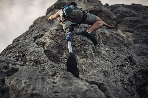 Man with prosthetic leg free mountain climbing