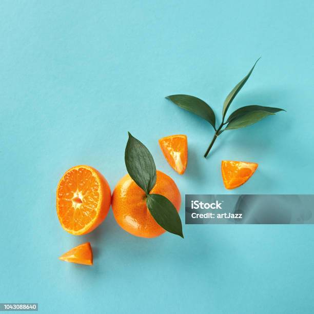 Flat Lay Exotic Citrus Fruits With Green Leaves On A Blue Paper Background Stock Photo - Download Image Now