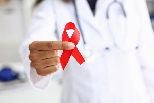 Black woman doctor holding a red ribbon Black woman doctor holding a red ribbon in his hand an international day of protecting people from cancer by symbol of struggle and survival mankind brest brittany photos stock pictures, royalty-free photos & images