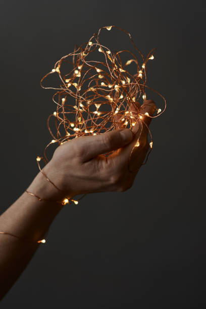 istock bright christmas lights in woman's hands 1043089900
