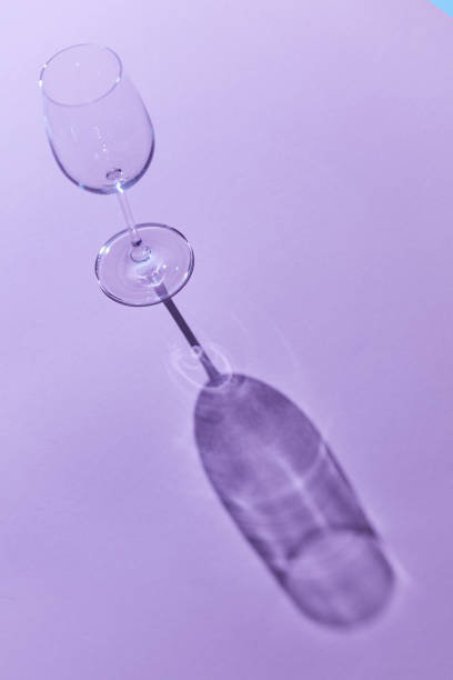 istock wineglass sunlight and shadow on a purple background 1043090014