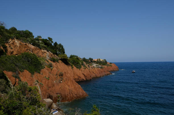 the corniche de l'esterel seen from the sea on board a ferry the corniche de l'esterel seen from the sea on board a ferry that runs along the entire French coast between cannes and saint-raphael corniche de lesterel stock pictures, royalty-free photos & images