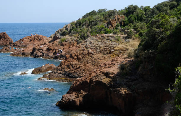 the corniche de l'esterel seen from the sea on board a ferry the corniche de l'esterel seen from the sea on board a ferry that runs along the entire French coast between cannes and saint-raphael corniche de lesterel stock pictures, royalty-free photos & images