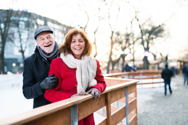 älteres paar bei einem spaziergang durch eine stadt im winter. - couple senior adult travel action stock-fotos und bilder