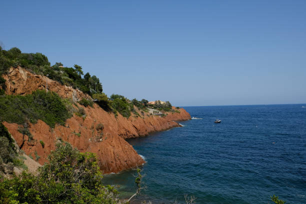 the corniche de l'esterel seen from the sea on board a ferry the corniche de l'esterel seen from the sea on board a ferry that runs along the entire French coast between cannes and saint-raphael corniche de lesterel stock pictures, royalty-free photos & images