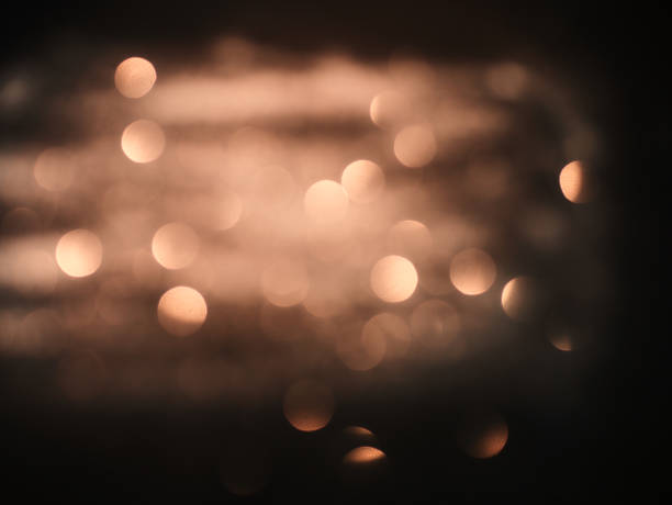 istock Blurred background lights. Abstract defocused gold, white, red and yellow glitters texture on black background. Shining glowing snow effects 1043104222