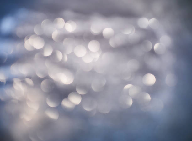 istock Blurred background lights. Abstract defocused gold, blue, white, red and yellow glitters texture on black background. Shining glowing snow effects 1043104262