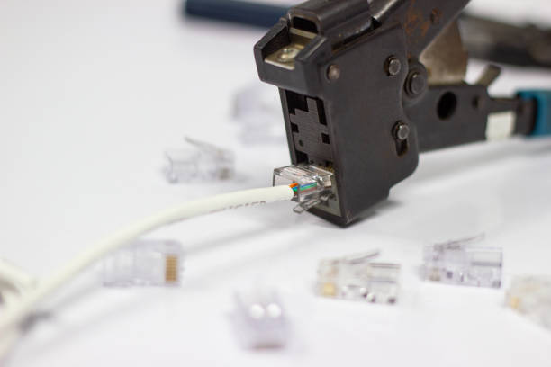 istock Technician to install an RJ45 connector on a CAT5 Ethernet network 1043107396