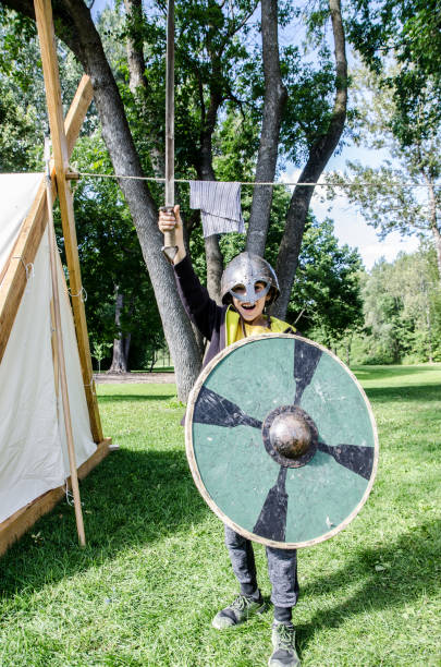 istock Boy dressed as a Celtic warrior and holding shield and sword in the air during summer day at Celtic Festival of Quebec city 1043110150