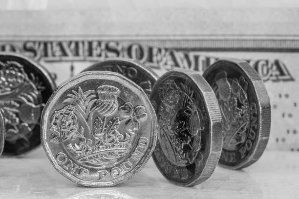 istock One pound coins and US currency 1043132624