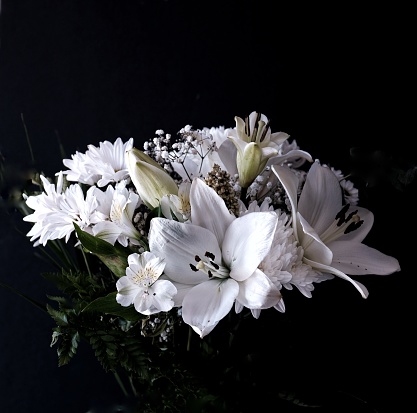 White flowers in bouquet suitable for wedding or Funeral. Black background and copy space
