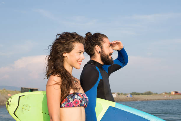 istock Surfing couple looking in distance 1043141564