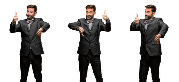 istock Middle age man, with beard and bow tie confused with thumbs up and down, trying to take a decision expressing doubt and frustration 1043141874