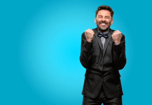 istock Middle age man, with beard and bow tie happy and surprised cheering expressing wow gesture 1043146324