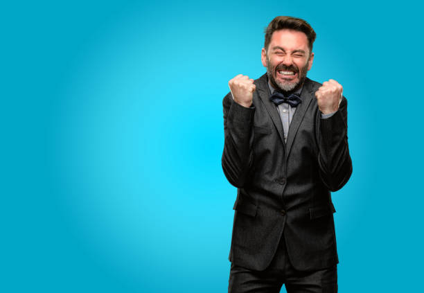 istock Middle age man, with beard and bow tie happy and surprised cheering expressing wow gesture 1043146364