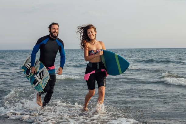 istock Surfing couple at the beach 1043146762