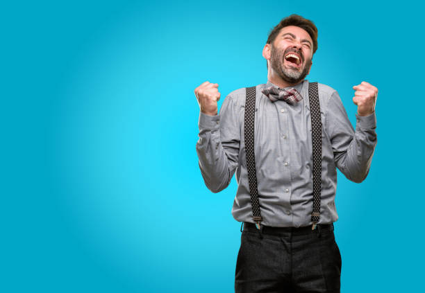 istock Middle age man, with beard and bow tie happy and excited expressing winning gesture. Successful and celebrating victory, triumphant 1043146892