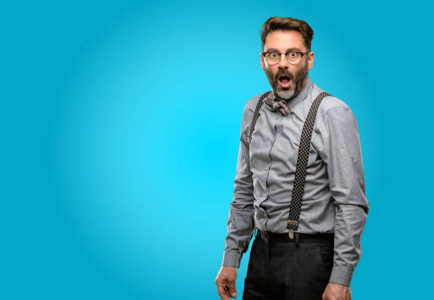 istock Middle age man, with beard and bow tie scared and surprised cheering expressing wow gesture. Unbelieving 1043147552