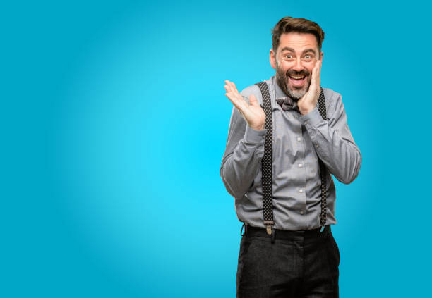 istock Middle age man, with beard and bow tie holding something in empty hand 1043147764