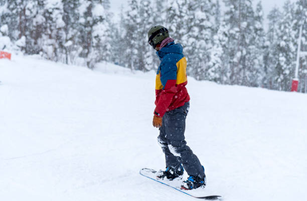 istock Young man snowboarding in snowfall 1043148060