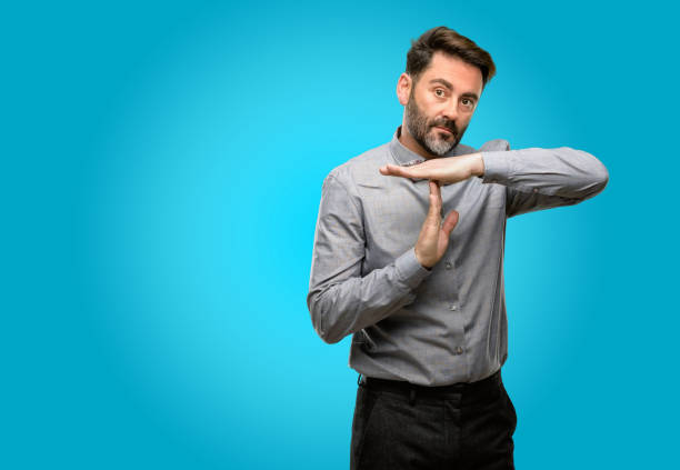 istock Middle age man, with beard and bow tie serious making a time out gesture with hands 1043148124