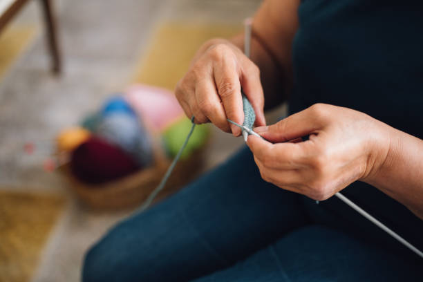 istock Mature woman knitting at home 1043148256
