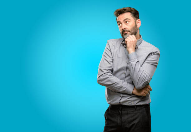 istock Middle age man, with beard and bow tie thinking and looking up expressing doubt and wonder 1043152720