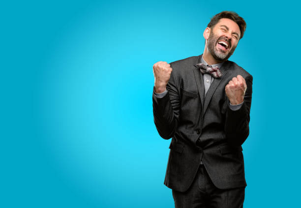 istock Middle age man, with beard and bow tie happy and excited celebrating victory expressing big success, power, energy and positive emotions. Celebrates new job joyful 1043153272