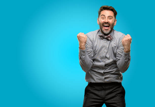 istock Middle age man, with beard and bow tie happy and excited celebrating victory expressing big success, power, energy and positive emotions. Celebrates new job joyful 1043153340