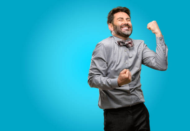 istock Middle age man, with beard and bow tie happy and excited celebrating victory expressing big success, power, energy and positive emotions. Celebrates new job joyful 1043153476