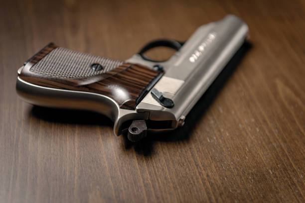 istock Gun on wood background 1043154130