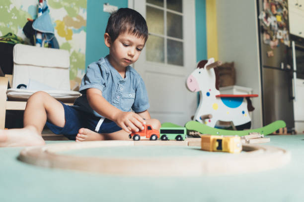 istock Cute little boy playing with wooden train 1043157548