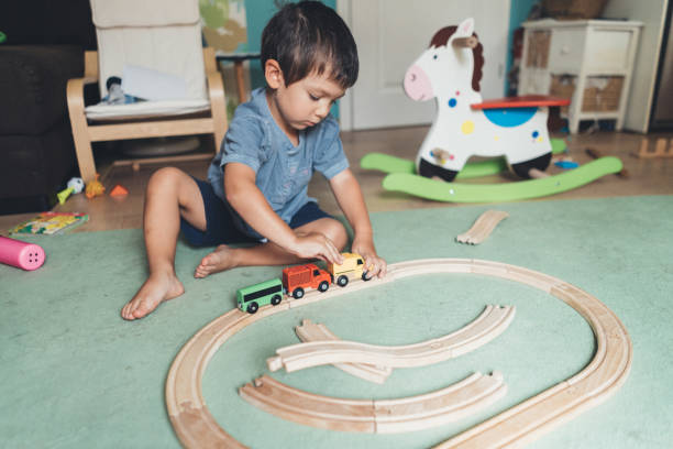istock Cute little boy playing with wooden train 1043157558