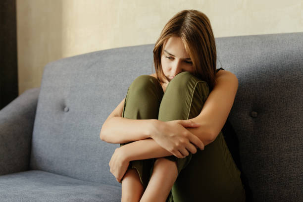 istock Sad woman sitting on the sofa, at home 1043165898
