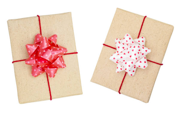 istock Two wrapped  gift boxes with red ribbon bow and heart, isolated on white, top view 1043166264