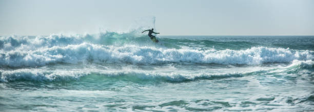istock Silhouette surfer riding waves, Fistral, Newquay, Cornwall 1043166702