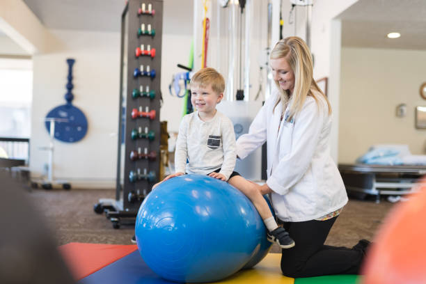 istock Physical therapist working with a young boy in the clinic 1043169098