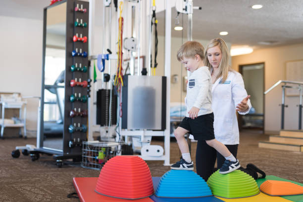 istock Physical therapist working with a young boy in the clinic 1043169140