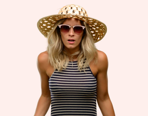 istock Young woman using sunglasses wearing summer hat scared in shock, expressing panic and fear 1043169306