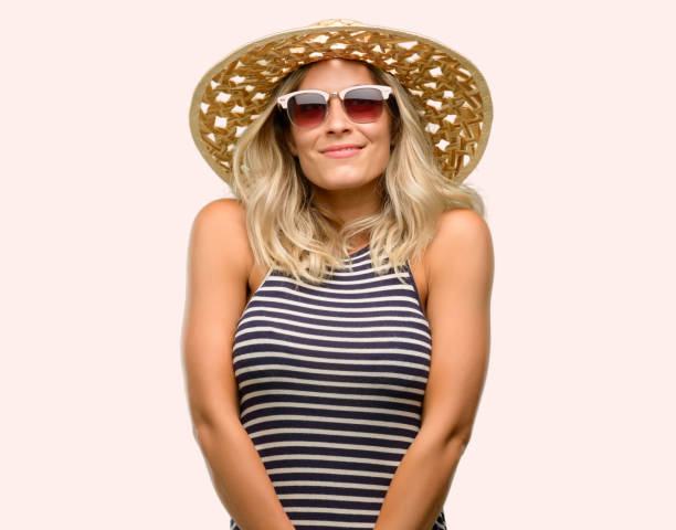 istock Young woman using sunglasses wearing summer hat thinking and looking up expressing doubt and wonder 1043169314