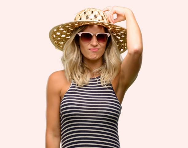 istock Young woman using sunglasses wearing summer hat doubt expression, confuse and wonder concept, uncertain future 1043169334