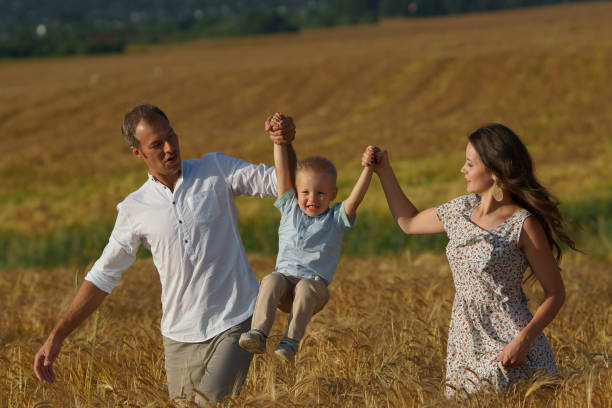 istock Happy smiling family walking through a wheat field 1043178248