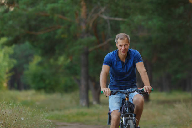 istock Smiling cyclist rides on bicycle in pine forest 1043178480