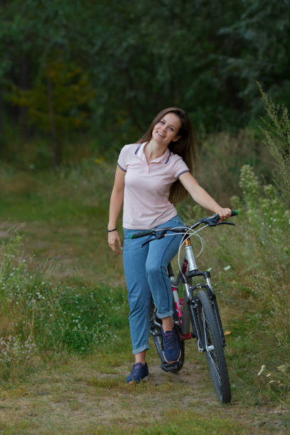 istock Young woman riding on bicycle in the forest. 1043178486