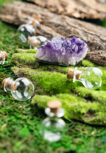 istock Magic flask and amethyst stone on emerald moss in the forest. Halloween theme. Witchcraft and herbalism. 1043180070