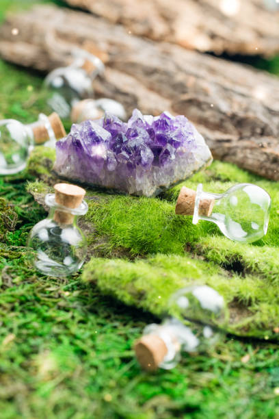 istock Magic flask and amethyst stone on emerald moss in the forest. Halloween theme. Witchcraft and herbalism. 1043180096