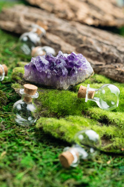 istock Magic flask and amethyst stone on emerald moss in the forest. Halloween theme. Witchcraft and herbalism. 1043180106