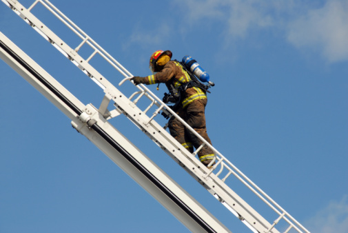 Firefighters using fire hose extinguishing burning fire