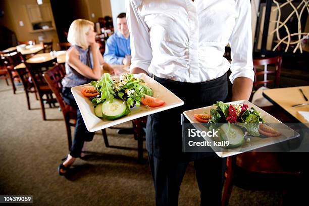 Vista Ritagliata Di Cameriera Con Insalata Piatti Al Ristorante - Fotografie stock e altre immagini di Cameriere